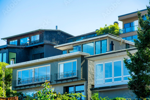 Row of modern houses in the historic districts of San Francisco California in downtown shade with visible windows on stucco houses