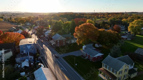 Historic homes in small American town at sunset. Road passes through village. Aerial view at sunrise. photo