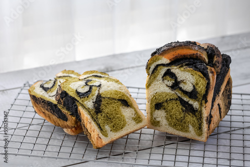 fresh baked black sesame greentea bubka bread loaf sliced on rack photo