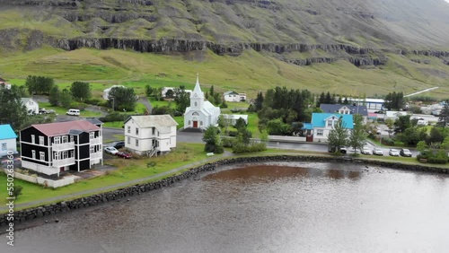 aerial flying over Seydisfjordur villege in Iceland with a small church photo