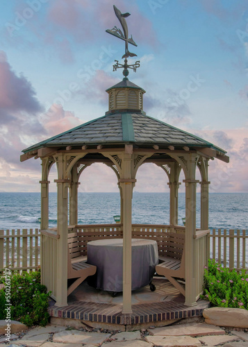 Vertical Puffy clouds at sunset Gazebo with built in seat and table in a beautiful garden at La
