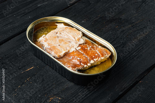 Smoked Salmon Fillets Canned fish, in tin can, on black wooden table background, with copyspace  and space for text