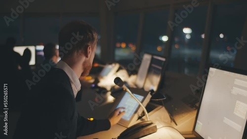 Close up of traffic control center operator working in airoport tower at night photo