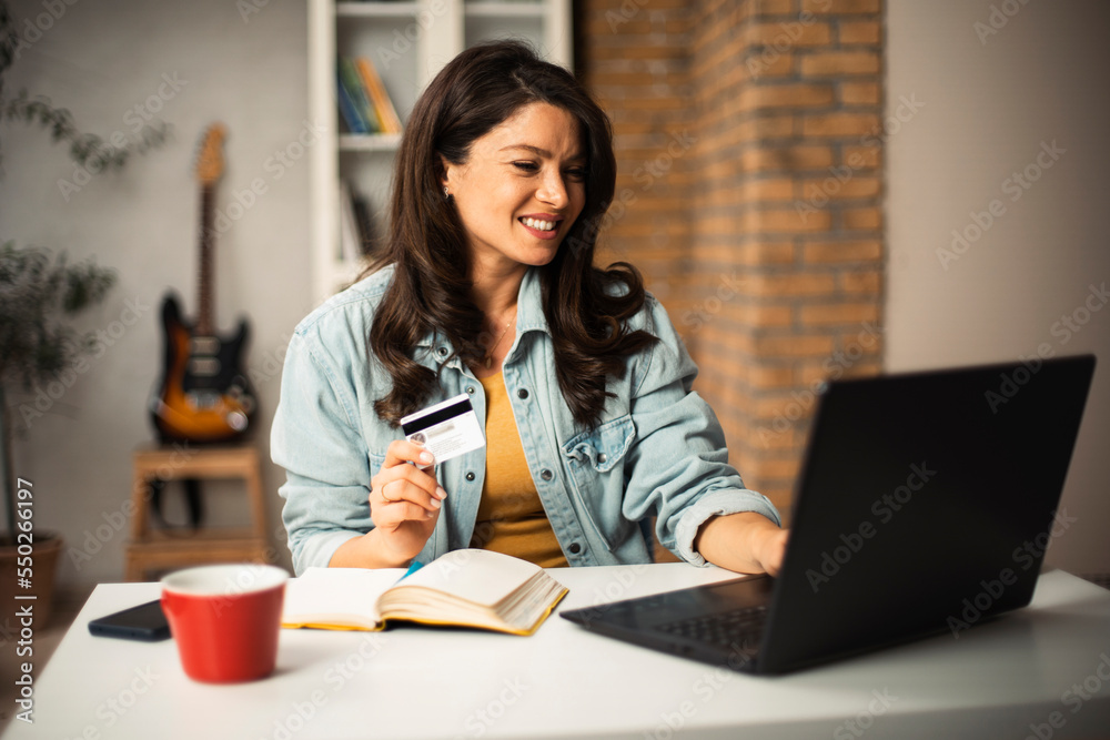 Pregnant woman shopping online at home. Happy woman with laptop and credit card.. Pregnant woman shopping online at home. Happy woman with laptop and credit card..