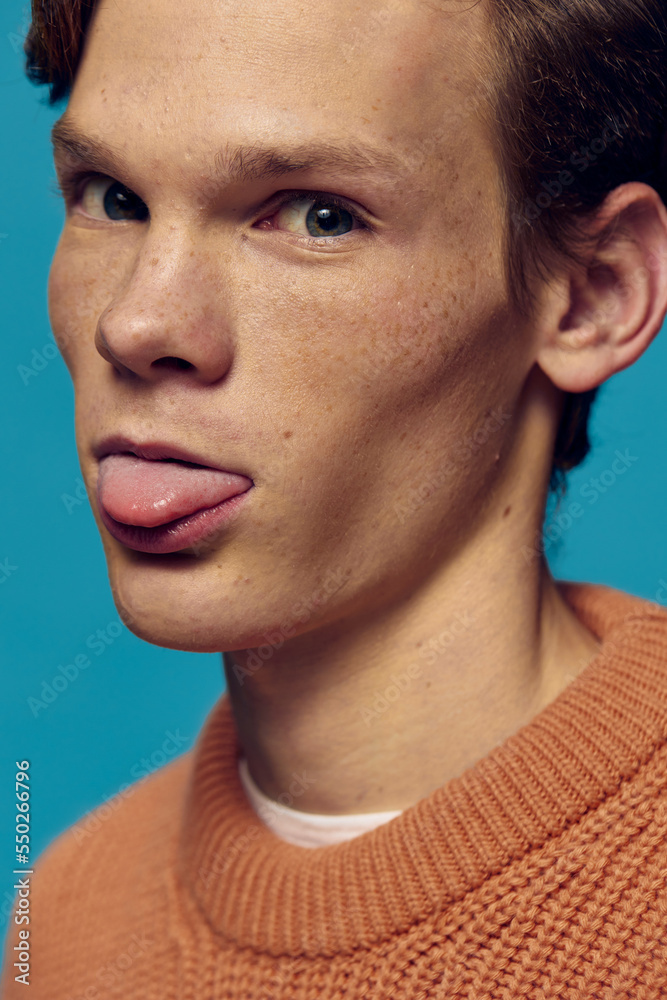 Obraz premium close portrait of funny guy with freckles showing tongue