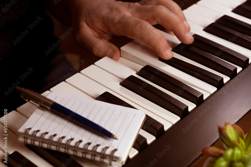 Man composing music on a midi keyboard