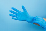 Hand wearing blue medical gloves, hygiene and safety, before surgery operation, doing medication for patients people healthy life style concept
