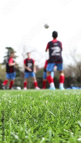 unrecognizable young soccer team training and doing workout routines, out of focus shot. vertical video for smart phone