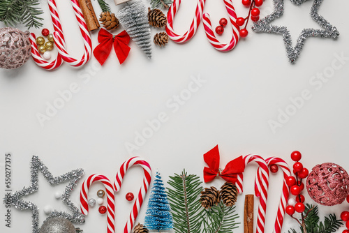 Composition with candy canes and different Christmas decorations on white background