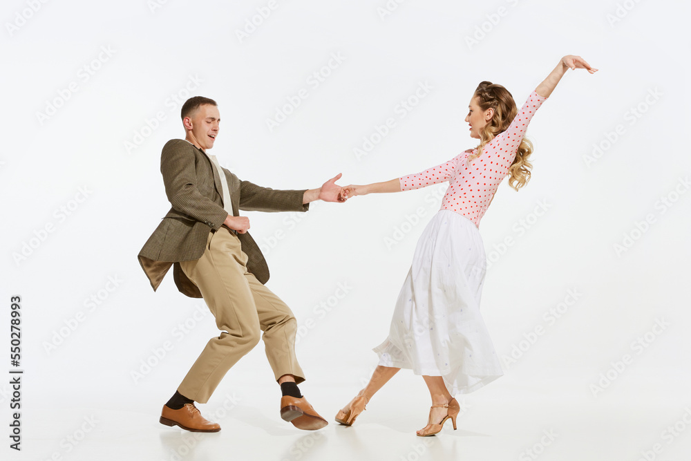 Two emotional dancers in vintage style clothes dancing swing dance, rock-and-roll or lindy hop isolated on white background. 1960s american fashion style and art. - obrazy, fototapety, plakaty 