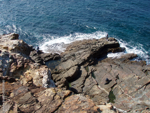 Looking down the sunny blue sea and rock surf fishing point (Nanki Shirahama-cho)