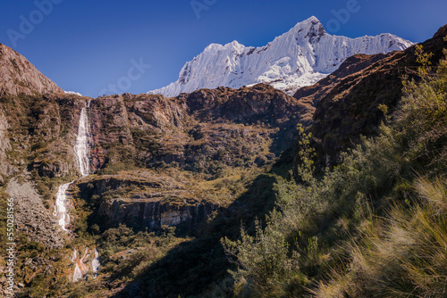 Waterfall and Huascaran massif in Cordillera Blanca, snowcapped Andes, Ancash, Peru