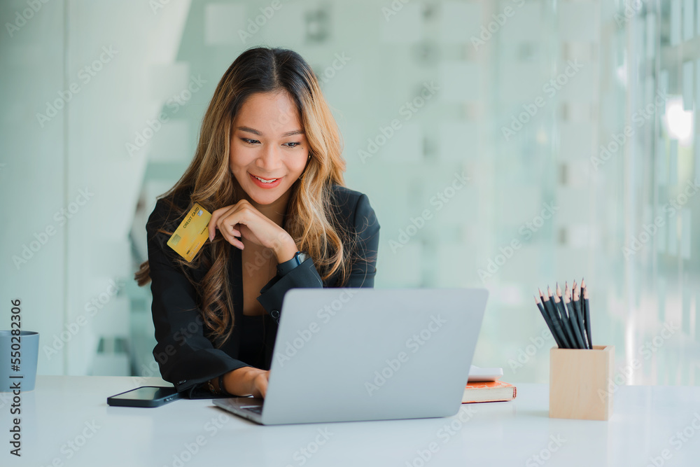 Asian businesswoman lifestyle doing financial transactions with laptop computer enjoying online shopping with credit card Asian businesswoman lifestyle doing financial transactions with laptop computer enjoying online shopping with credit card