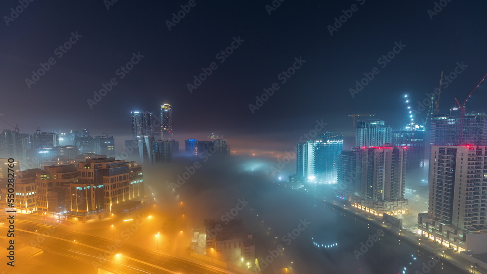 Buildings are covered in thick layer of fog in Business Bay night timelapse.