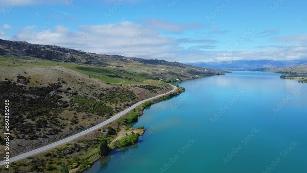 Drone around road that runs along blue new zealand lake Drone around road that runs along blue new zealand lake