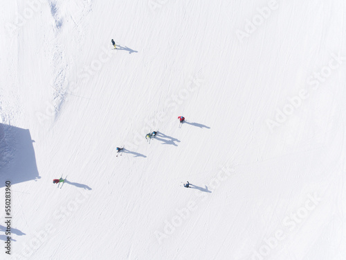 Fotografie Top view of skiers and snowboarders with long shadow