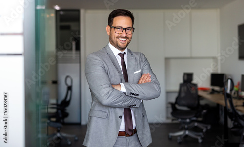 Portrait of young successful ceo businessman smiling in corporate office photo