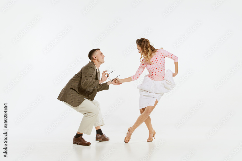 Dynamic portrait of happy, stylish and energetic dancers dancing lindy hop or swing dance isolated on white background. Music, energy, happiness, mood, action Dynamic portrait of happy, stylish and energetic dancers dancing lindy hop or swing dance isolated on white background. Music, energy, happiness, mood, action