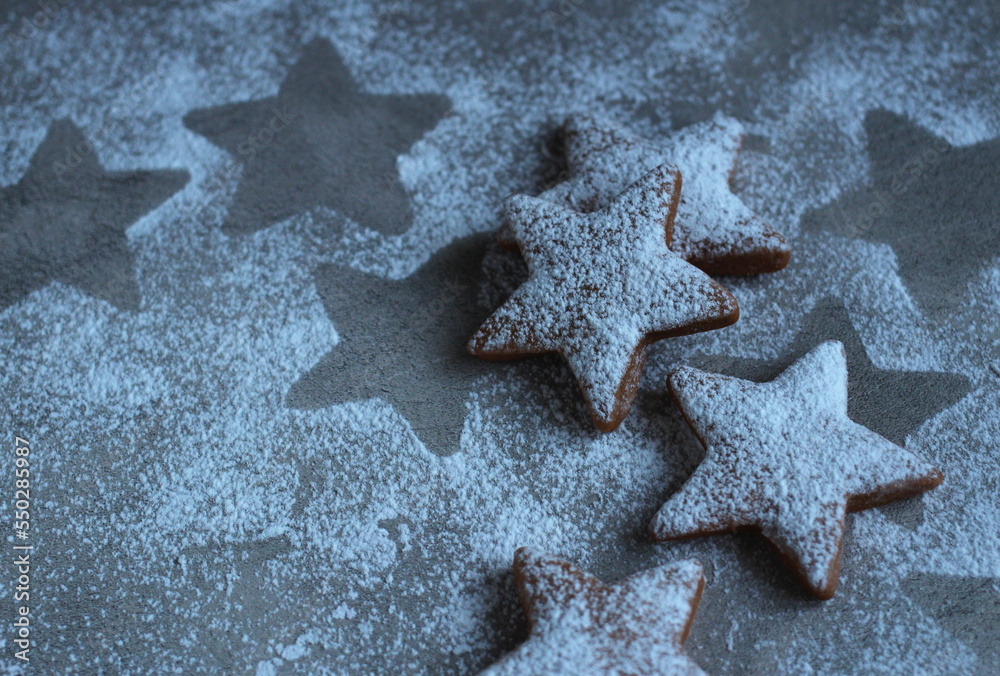 curly cookies in the form of a star in powdered sugar on a gray background curly cookies in the form of a star in powdered sugar on a gray background