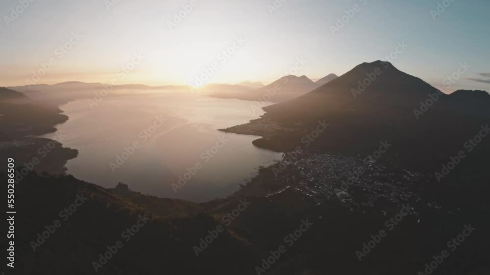 Bright golden sunrise above silhouette of mountains near lake Atitlan, aerial view