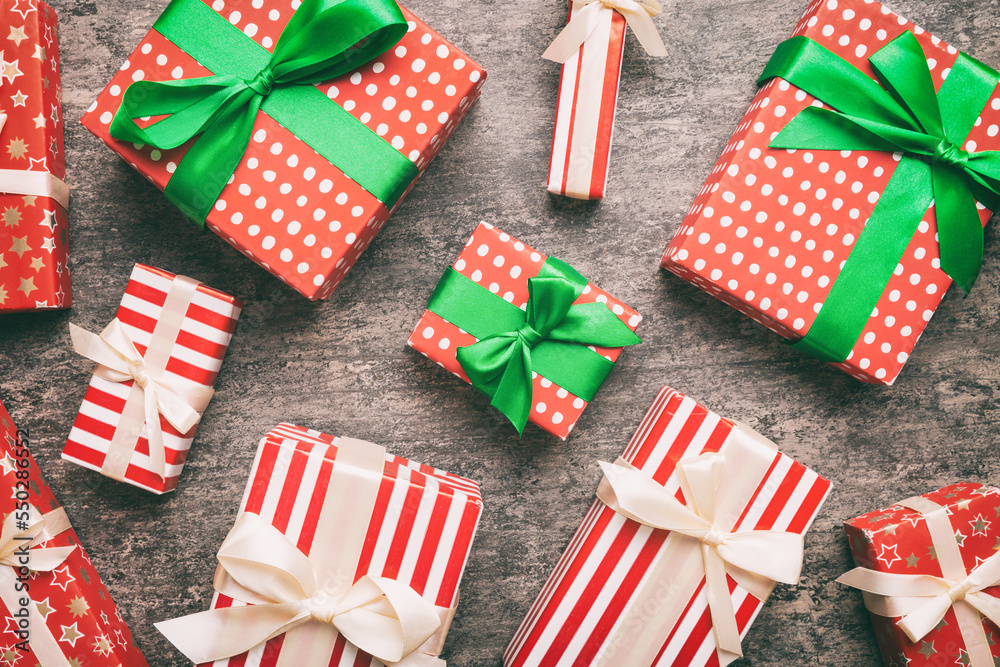 Fototapeta premium A lot of Christmas gift boxes in colored paper decorated on table, Top view close up. Many present New Year gift