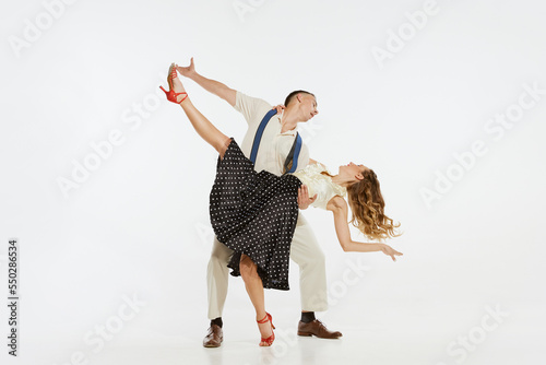 Photography Dynamic portrait of happy, stylish and energetic dancers dancing lindy hop or swing dance isolated on white background