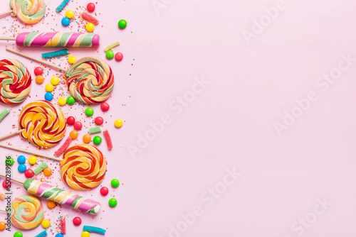 Tasty appetizing Party Accessories Happy Birthday Sweet. Different types of candies on colored background, copy space. Colorful birthday party background