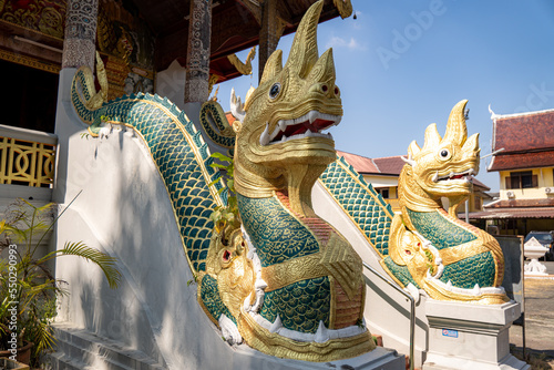 Fotografia Eingang in einen asiatischen Tempel mit Drachen an der Treppe in Grün und Gold