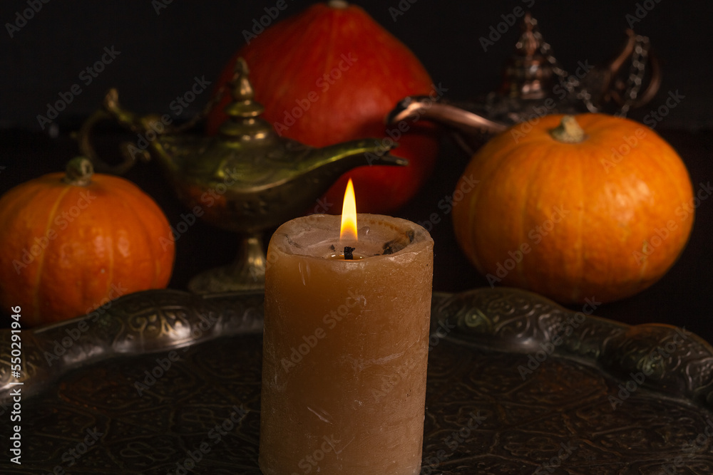 Yellow-orange pumpkins candle tray Aladdins lamp on a black background the concept of Halloween and the autumn harvest of pumpkin close-up copyspace from above Yellow-orange pumpkins candle tray Aladdins lamp on a black background the concept of Halloween and the autumn harvest of pumpkin close-up copyspace from above