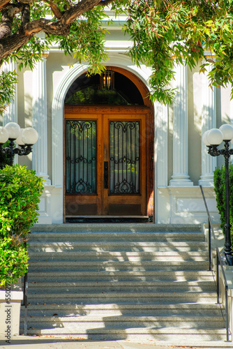 Foto Wooden door entrance with front step stairs with black metal gaurd rail with sur
