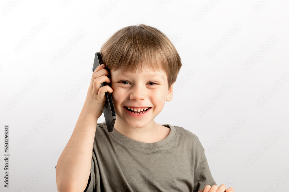 Boy speaks on the phone on a light background Boy speaks on the phone on a light background