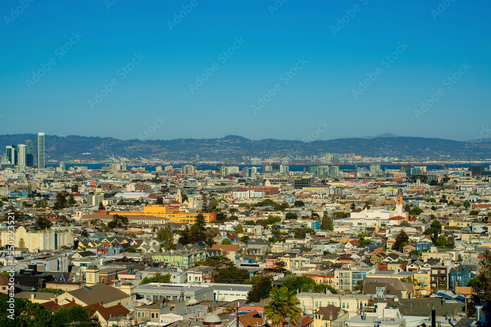 Sprawling cityscape with downtown city buildings and neighborhoods with houses in late afternoon sun in San Francisco California