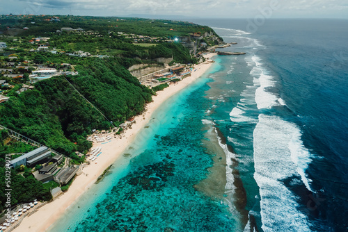 Aerial view of popular Bali beach with turquoise ocean and waves in Bali