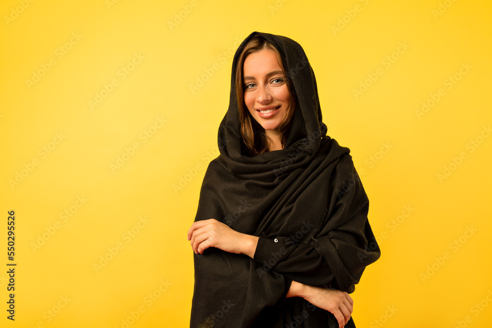 Lovely adorable woman with big blue eyes and wonderful smile posing at camera over yellow wall