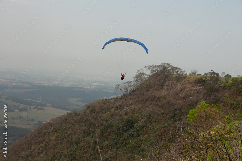man flying a paraglider in a natural landscape man flying a paraglider in a natural landscape