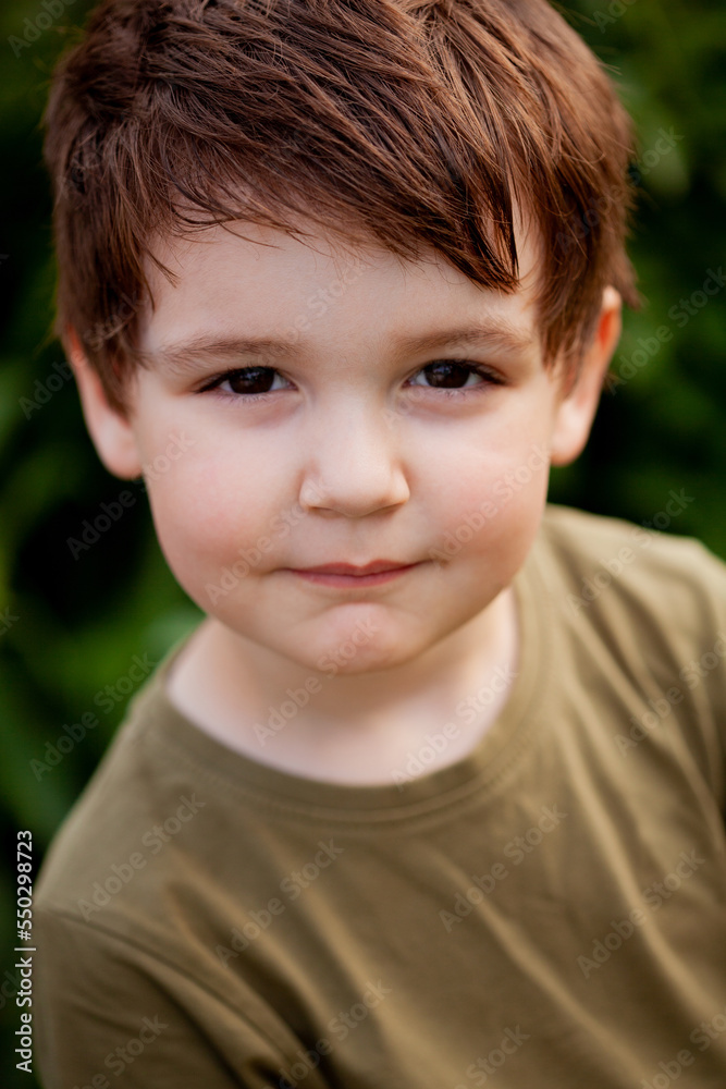 portrait of a boy outside in natural light, the boy staring straight into the camera portrait of a boy outside in natural light, the boy staring straight into the camera