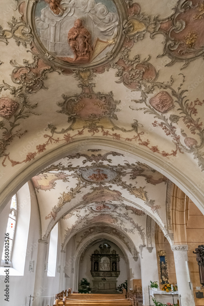 Lovely view of the side aisle with the elaborately designed rococo stucco ceilings from 1746 in the famous St. Gangolf's Church, a Roman Catholic church in Trier, Germany.
