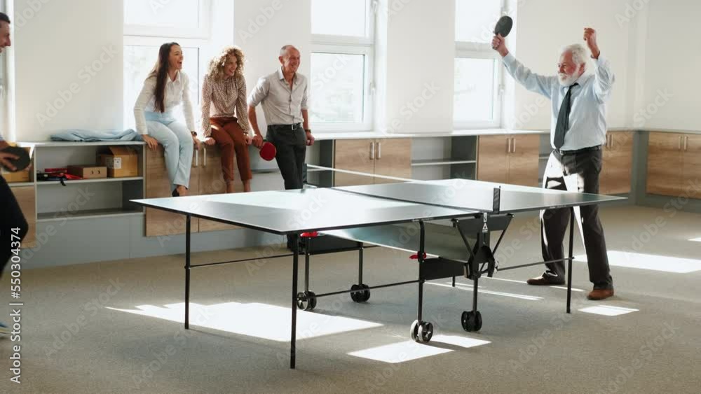 Happy business people are relaxing during work break playing ping pong in office. Happy business people are relaxing during work break playing ping pong in office.