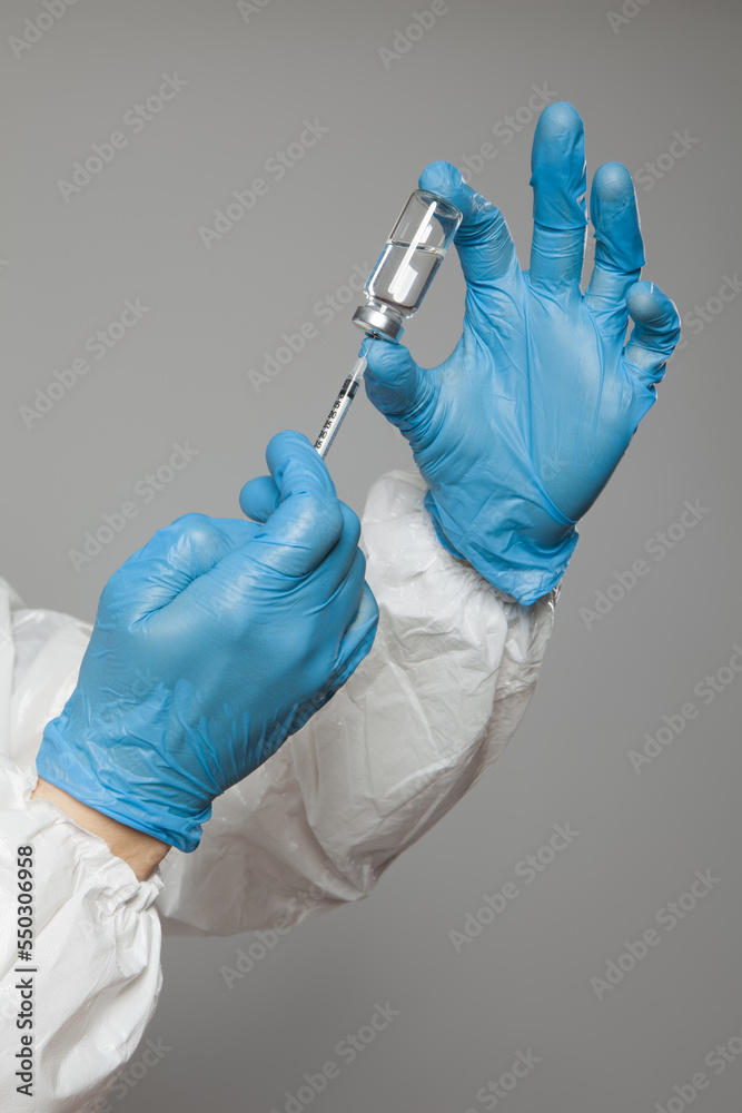 Closeup of syringe in doctor or nurse's hand from a vial to vaccinate into patients for immunization. Vaccination concept. Closeup of syringe in doctor or nurse's hand from a vial to vaccinate into patients for immunization. Vaccination concept.