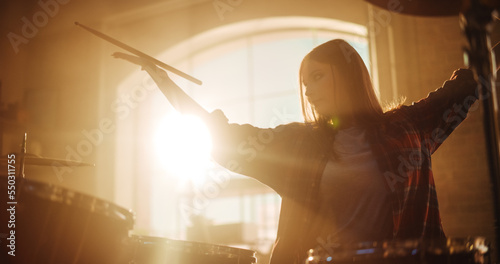 Close Up Portrait of an Expressive Drummer Girl Playing Drums in a Loft Music Rehearsal Studio Filled with Light. Rock Band Music Artist Learning a New Drum Solo for Upcoming Big Concert.