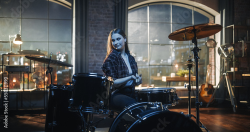 Expressive Drummer Girl Playing Drums in a Loft Music Rehearsal Studio at Night. Rock Band Music Artist Learning a New Drum Solo. Woman Practicing Before Big Concert with Audience.