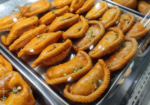 Gujia is a sweet deep-fried dumpling, native to the Indian subcontinent, made with flour stuffed with a mixture of sweetened milk solids and dried fruits and fried in ghee. photo