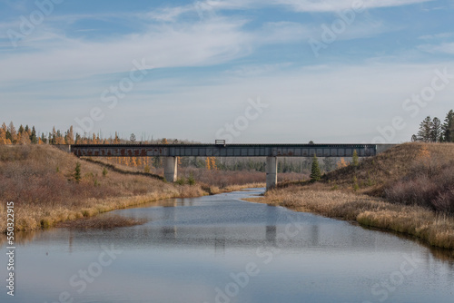Autumn view of a railroad bridge over a river in rural countryside in Saskatchewan, Canada.