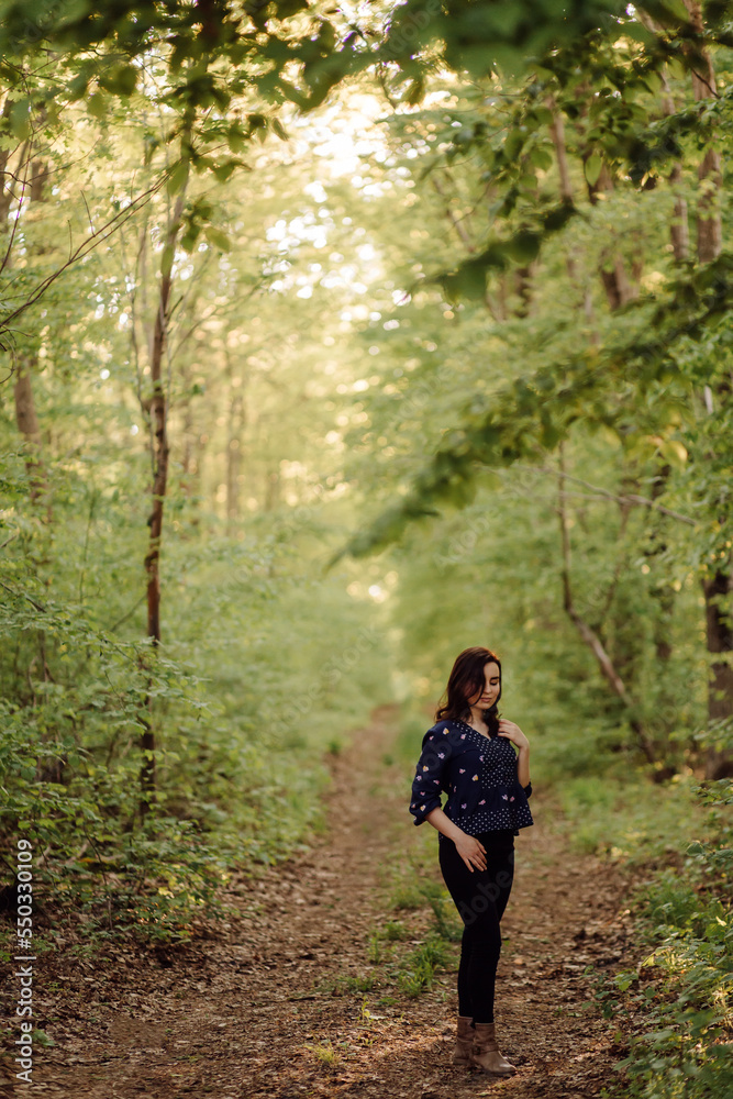 A beautiful young woman walking in the forest A beautiful young woman walking in the forest