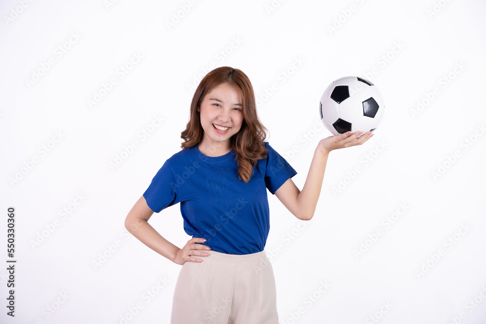 Asian woman smiling in blue t-shirt holding football to cheering the soccer game isolated on white screen background. Asian woman smiling in blue t-shirt holding football to cheering the soccer game isolated on white screen background.