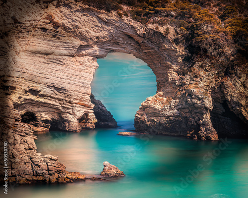 natural arch above green sea
