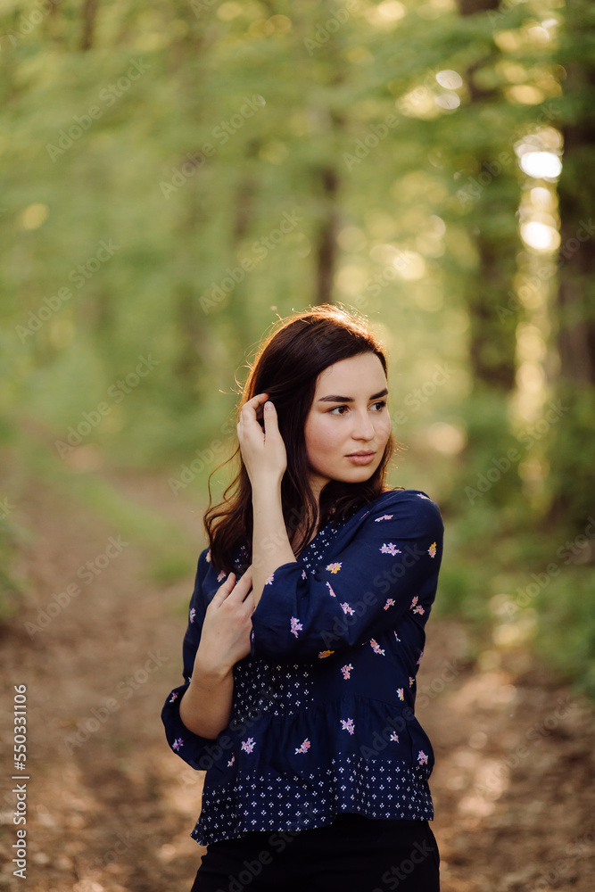 A beautiful young woman walking in the forest