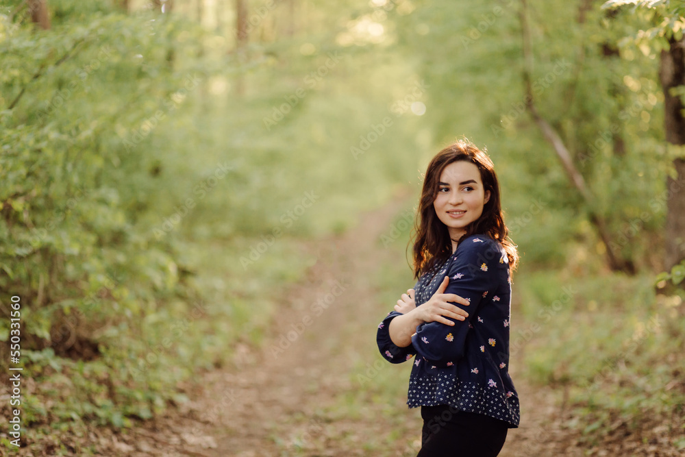 A beautiful young woman walking in the forest A beautiful young woman walking in the forest