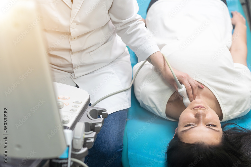 Doctor using ultrasound scanning machine for examining a thyroid of woman. Doctor using ultrasound scanning machine for examining a thyroid of woman.