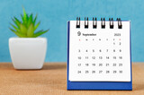 The September 2023 desk calendar wiht platn pot on blue color background.